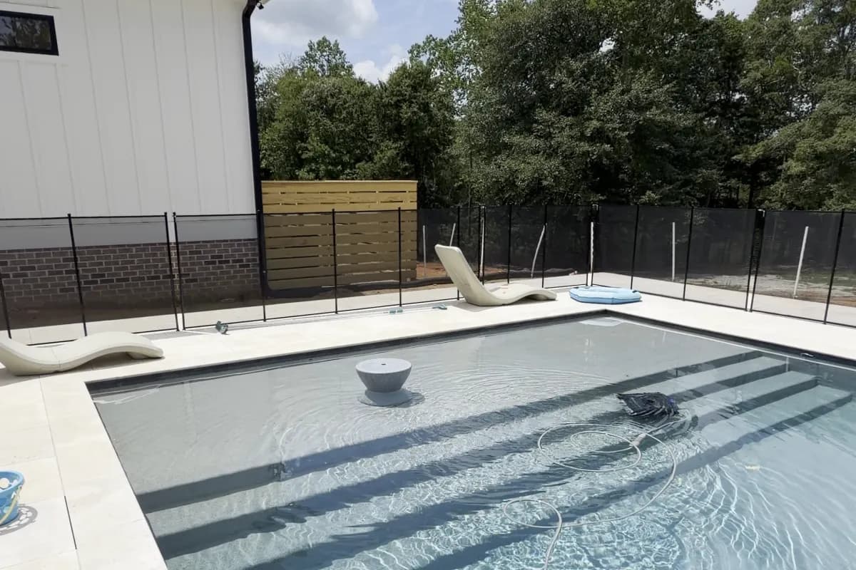 Rectangular pool with a tanning ledge and bowl fountain